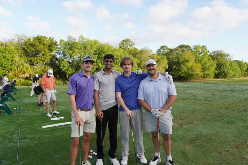 Christian with teammates on the driving range