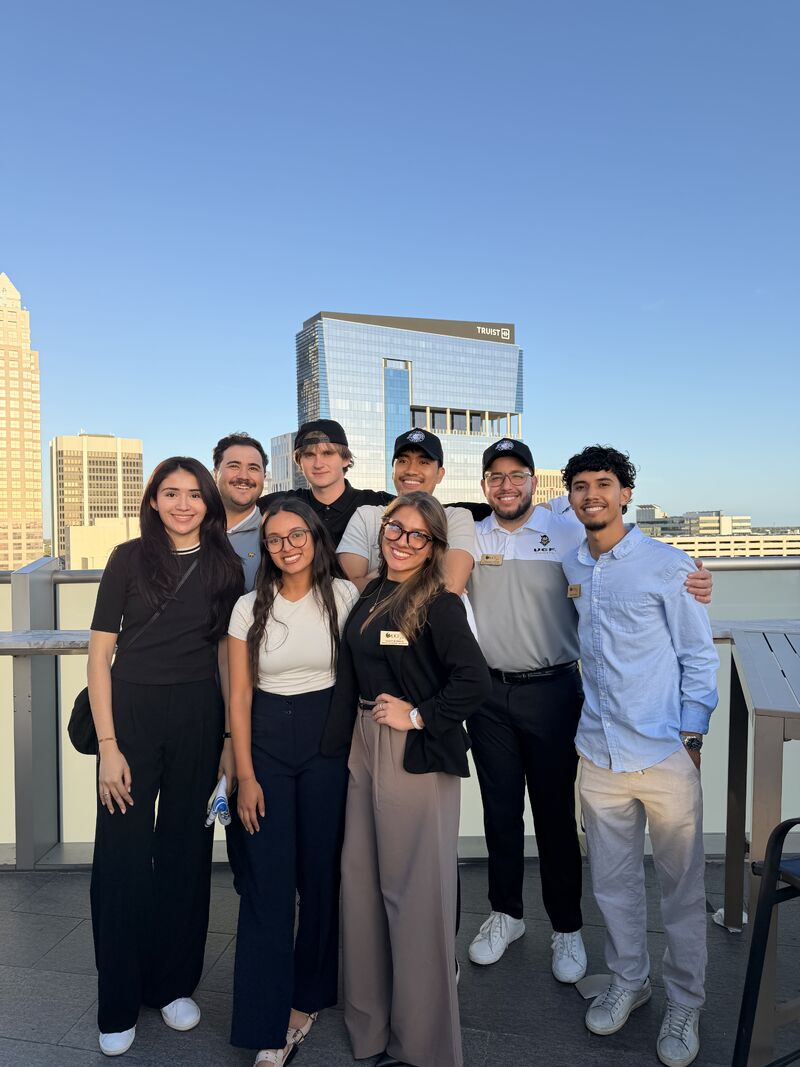 Christian with ALPFA UCF members on a rooftop with a city skyline